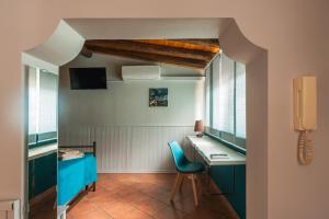 a room with a desk and a blue chair at Ciauru ri Casa in Mascalucia
