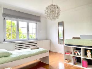 a bedroom with two beds and a chandelier at Villa piscine privée 8-10 pers Strasbourg 10 min in Mundolsheim +52 photos