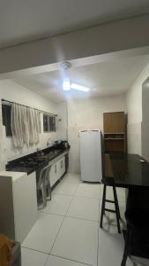 a kitchen with a stove and a white refrigerator at Apartamento em Pitangueiras in Guarujá