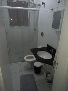 a bathroom with a sink and a toilet at Apartamento em Pitangueiras in Guarujá