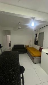 a living room with a bed and a couch at Apartamento em Pitangueiras in Guarujá