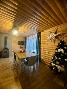 a dining room with a table and a christmas tree at Istebna Pełna Chata I in Istebna