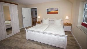 a large white bed in a bedroom with two lamps at Fewo am Iberg 20, inkl Parkplatz in Willingen