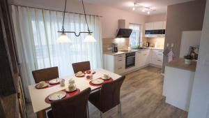 a kitchen with a white table and chairs and a kitchen with a table and chairs at Fewo am Iberg 20, inkl Parkplatz in Willingen