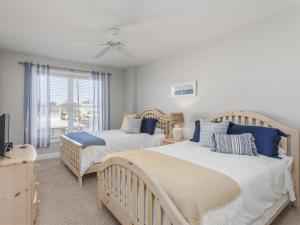 two beds in a bedroom with a window at Ocean Pearl in Tybee Island +43 photos