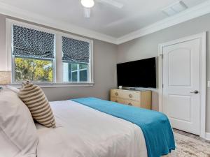 a bedroom with a bed and a tv and windows at Beachside Villa Unit 3 in Tybee Island +26 photos