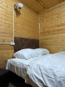 a bedroom with a bed with a wooden wall at Cottages Lori Berd in Lori Berd