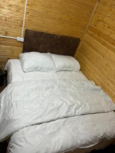 a bed with white sheets and pillows in a room at Cottages Lori Berd in Lori Berd +13 photos