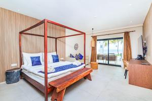 a bedroom with a canopy bed and a piano at Tamala Beach Resort in Kotu