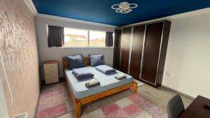 una piccola camera con un letto e un soffitto blu di Smart Stay a Craiova