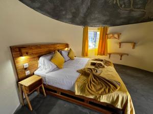 a bedroom with a large bed with yellow curtains at EcoFunco in Portela