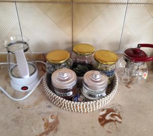 un panier rempli de bocaux sur un comptoir de cuisine dans l'établissement Jennys Vintage Studio - Motorcycle Friendly, à Dráma 15 autres photos