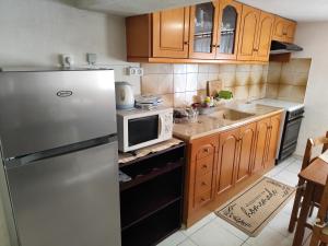 a kitchen with a stainless steel refrigerator and wooden cabinets at Jennys Vintage Studio - Motorcycle Friendly in Drama +15 photos