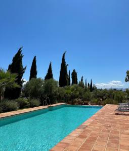 a swimming pool in a yard with trees at La Guzmana de Ronda in Ronda