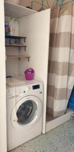 una lavadora y secadora en una habitación pequeña en Maison de charme avec Terrasse vue sur mer, en Rogliano
