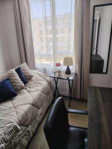 a bedroom with a bed and a table with a lamp at angysol in Antofagasta