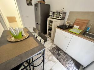 eine Küche mit Tisch und Kühlschrank in der Unterkunft Adua Luxury Apartment in Città Nuova