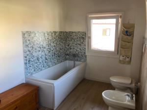 un bagno con vasca, WC e lavandino di Valentinas retreat a San Dorligo della Valle