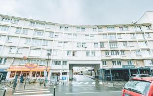 a large white building on a city street at Le Faidherbe Hotel Coeur de ville in Boulogne-sur-Mer