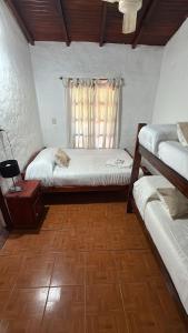 a bedroom with two beds and a window at EL PASO IBERA, cabañas equipadasy piscina in Colonia Carlos Pellegrini