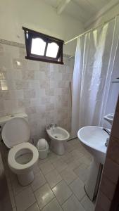 a bathroom with a toilet and a bidet and a sink at EL PASO IBERA, cabañas equipadasy piscina in Colonia Carlos Pellegrini