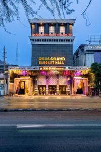 um prédio com uma placa que diz "Ogas Grand Banquete Hall" em Hotel Okas Grand em Nova Deli