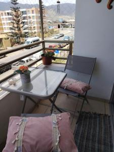 a table and chair on a balcony with a view of a street at angysol in Antofagasta +4 photos