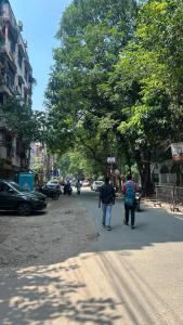 two people walking down a street in a city at Fully furnished 2 BHK Flat in kolkata +5 photos