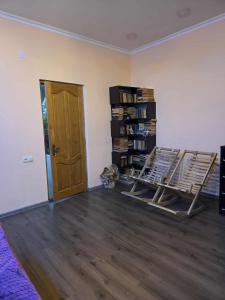 una habitación con dos mecedoras y una estantería en Kisa, en Martvili