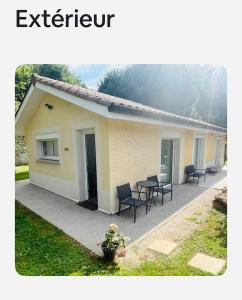 a building with chairs and a table in a yard at Maisonnette tout confort in Villette-dʼAnthon
