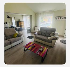 a living room with two couches and a coffee table at Maisonnette tout confort in Villette-dʼAnthon