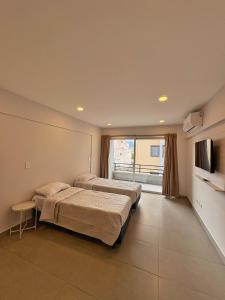 a hotel room with two beds and a tv at Otero Coliving - Studio Entero U4 in San Salvador de Jujuy