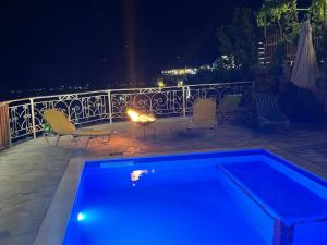 吉诺卡斯特Guesthouse Mele的游泳池在晚上配有桌椅
