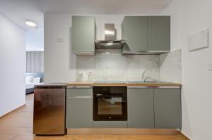 a kitchen with stainless steel appliances and gray cabinets at Tritoni Alta suites in Il-Gżira