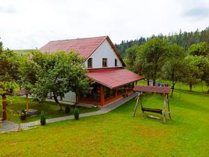 a house with a red roof in a yard at У Потічка in Izki