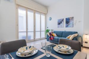 a living room with a table and a blue couch at La Villa Strangiato in Seregno