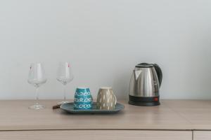 塞雷尼奥La Villa Strangiato的咖啡壶和2个吧台上的酒杯