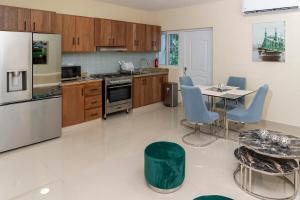 a kitchen with a table and blue chairs in it at La Isla Royal - Raya Cosmica in Miches