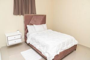 una camera da letto con un letto con lenzuola bianche e un comodino di La Isla Royal - Raya Cosmica a Miches