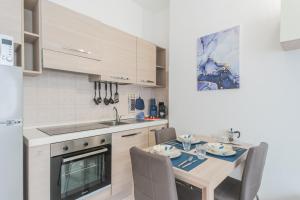 a kitchen with a table and a dining room at La Villa Strangiato in Seregno +46 photos