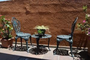 2 Stühle und ein Tisch mit Topfpflanze in der Unterkunft en corazón centro Histórico, in Morelia
