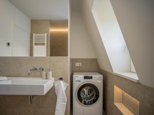 Gardenholm im Süden von Westerland في فيسترلاند: حمام مع غسالة ومغسلة