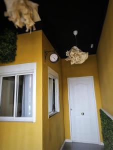 a room with a yellow wall and a white door and a clock at Cozy Room G20 in Valencia