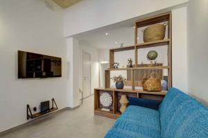 a living room with a blue couch and a tv at Charming Rabat Studio Stay in Rabat