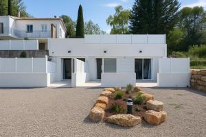 une maison blanche avec des rochers devant elle dans l'établissement La Dolce Vita Studios Clim Terrasse Privée Proche Draguignan, à Trans-en-Provence