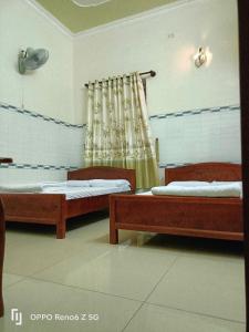 a room with two beds and a curtain at Lộ Kim Yến in Kon Rung (1)