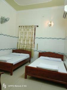 two beds sitting in a room with at Lộ Kim Yến in Kon Rung (1)