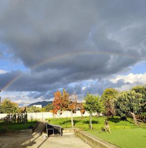 un arc-en-ciel au-dessus d'un parc avec un banc dans l'établissement Jennys Vintage Studio - Motorcycle Friendly, à Dráma