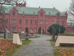 a large pink building with a pathway in front of it at Atlantis Apartmán 1 in Klášterec nad Ohří