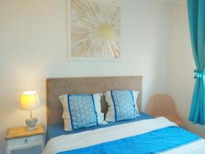 een slaapkamer met een bed met blauwe en witte kussens bij Apt au calme, 2-3 chambres, Sauna, 2 parkings, wifi in Montévrain